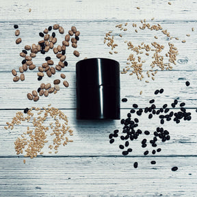 Extra-small black Seed Storage Vault surrounded by various seeds on a wooden surface